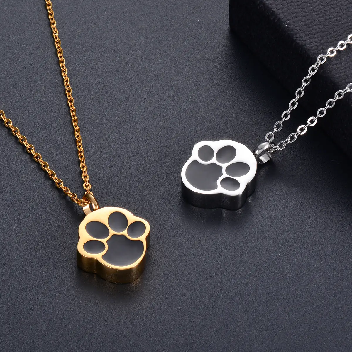 Gold and silver paw print pet memorial pendants close up