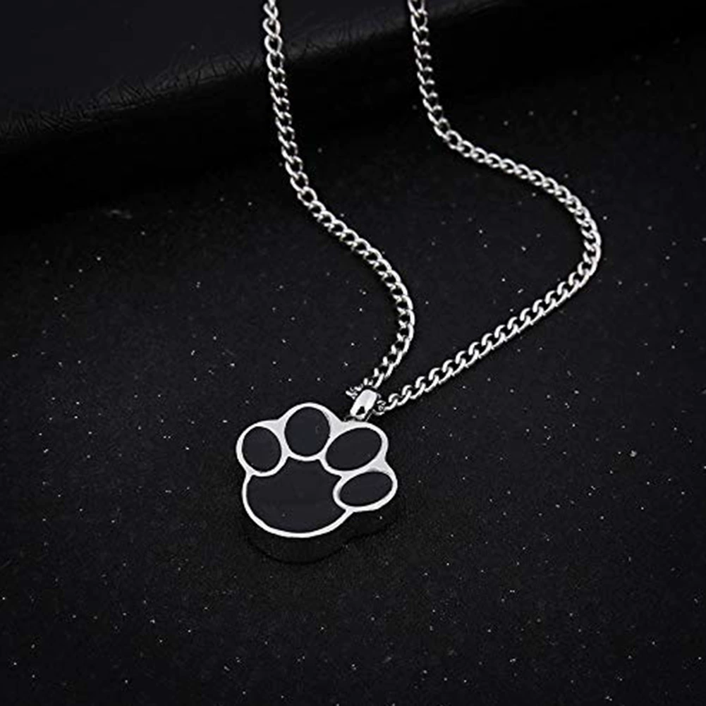 Silver paw print pet memorial necklace on black display