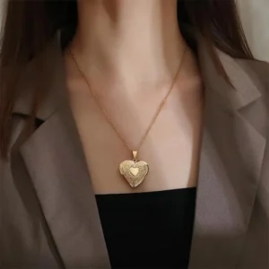 Woman wearing gold floral heart locket necklace